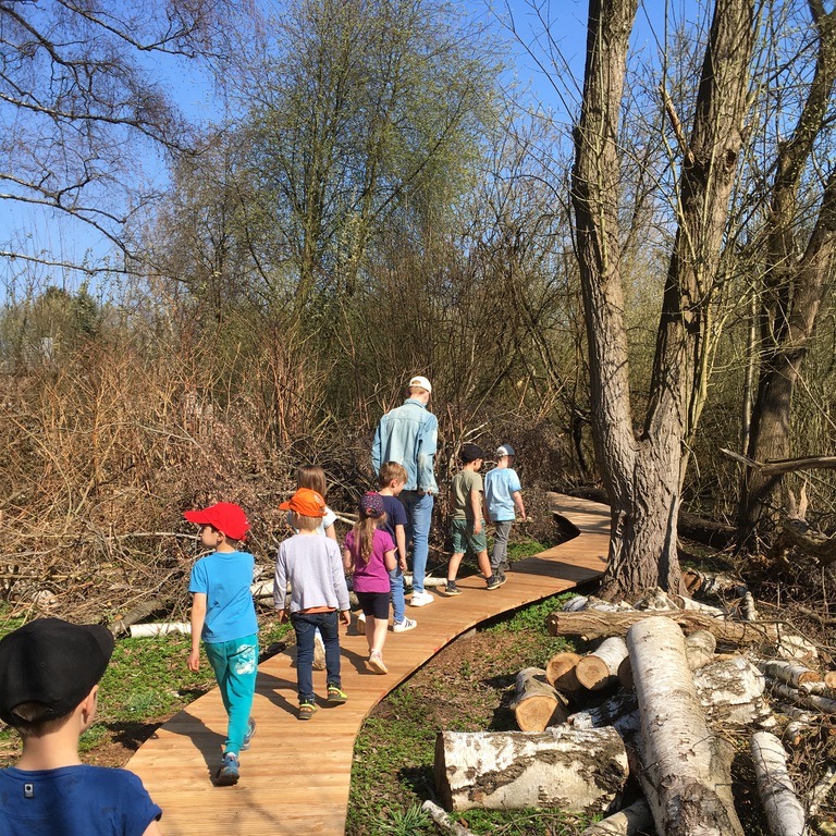 Kinder erkunden gemeinsam einen Naturbereich.