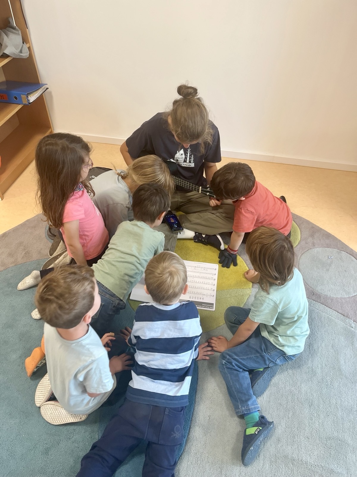 Eine pädagogische Fachkraft entdeckt gemeinsam mit Kindern die Natur.